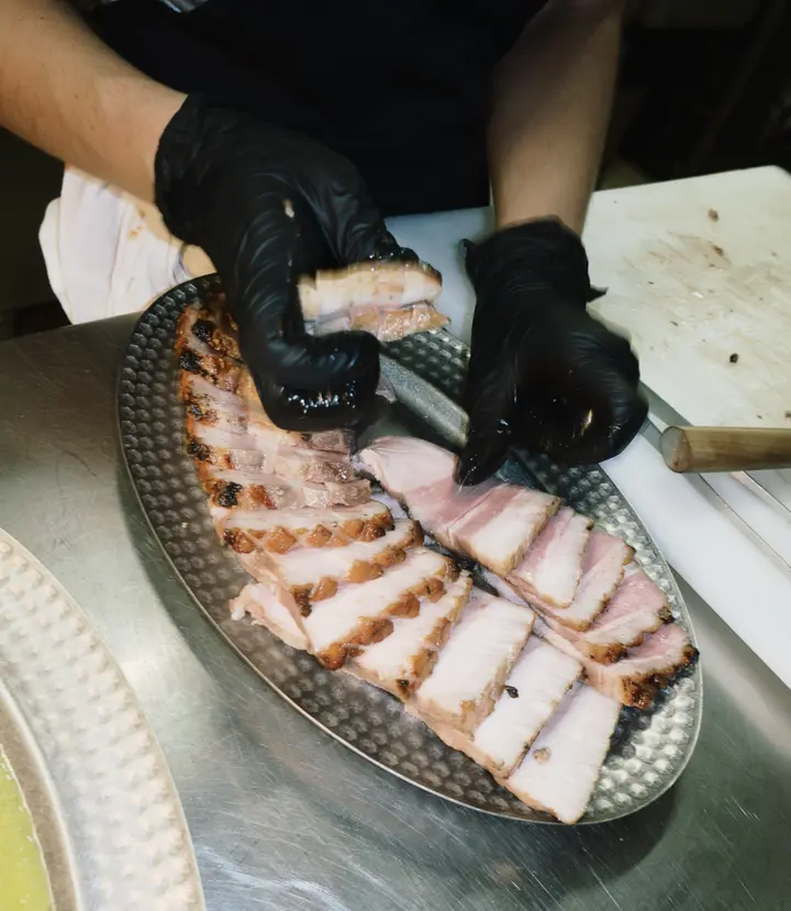 En cuisine, les mains dressent les tranches de viande sur un plat